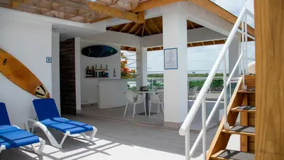 a room with a balcony with blue chairs and a table at Hotel Capriccio Mare y Restaurante in Punta Cana