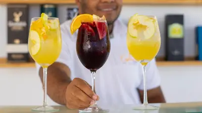 a man holding three cocktails in wine glasses at Hotel Capriccio Mare y Restaurante in Punta Cana