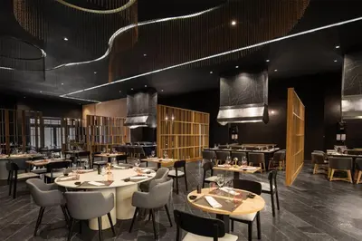 a dining room with tables and chairs and lights at Wyndham Alltra Punta Cana All Inclusive Resort in Punta Cana
