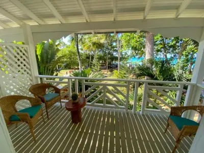 a porch with chairs and a potted plant on it at El Mosquito Boutique Hotel Playa Bonita in Las Terrenas
