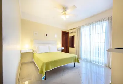 a bedroom with a bed with a yellow blanket at Hotel Shakey in Santo Domingo