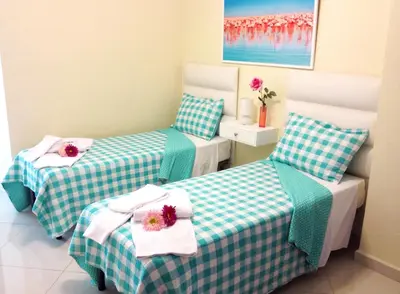 two beds in a small room with flowers on them at Hotel Shakey in Santo Domingo