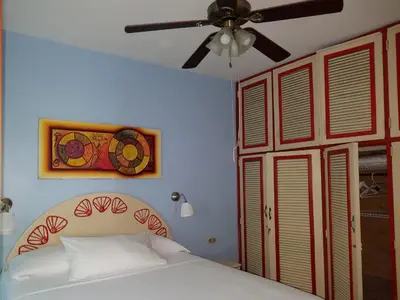 a bedroom with a bed and a ceiling fan at Las Palmeras RIKI R in Boca Chica