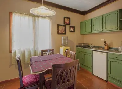 a kitchen with green cabinets and a table with a tableablish at Hotel San Marco in Santo Domingo