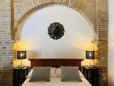 a bedroom with a large bed with two lamps at Paseo Colonial - El Monasterio #4 in Santo Domingo