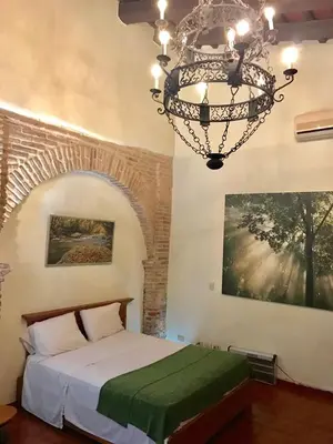 a bedroom with a bed and a chandelier at Paseo Colonial - El Monasterio #4 in Santo Domingo