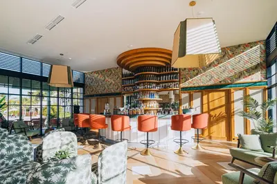 a bar in a restaurant with orange chairs at El Beso Adults Only At Ocean El Faro - All Inclusive in Punta Cana