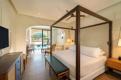 a bedroom with a bed and a desk and a television at El Beso Adults Only At Ocean El Faro - All Inclusive in Punta Cana