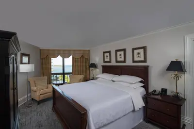 a bedroom with a large white bed and a chair at Sheraton Santo Domingo in Santo Domingo