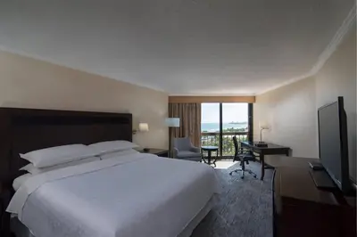 a hotel room with a bed and a desk and a television at Sheraton Santo Domingo in Santo Domingo