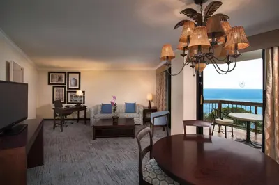 a living room with a dining table and a living room with the ocean at Sheraton Santo Domingo in Santo Domingo