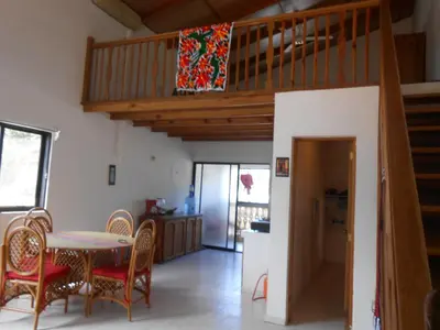 a kitchen and dining room with a table and a loft at 22 plaza rosada in Las Terrenas
