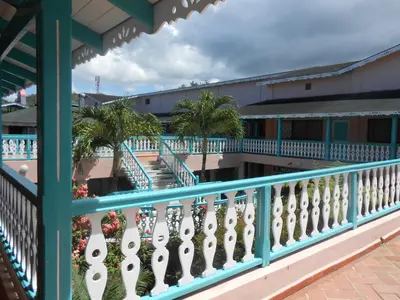 a balcony with a blue railing and palm trees at 22 plaza rosada in Las Terrenas