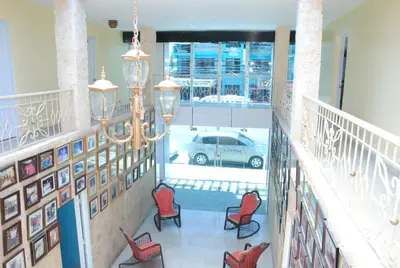 a hallway with red chairs and a car in a parking lot at Hotel Frano Romana Center in La Romana