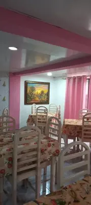 a dining room with tables and chairs and a painting on the wall at Hotel Frano Romana Center in La Romana