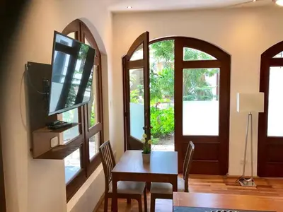 a living room with a table and a tv and a dining room at Paseo Colonial - Leo's Favorite #8 in Santo Domingo