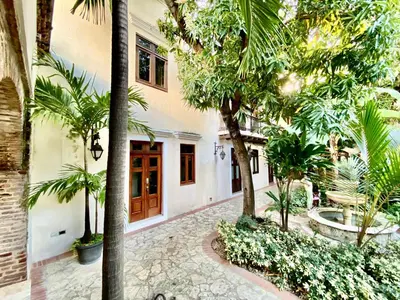 a courtyard with palm trees and a building at Paseo Colonial - Ermitage #5 in Santo Domingo