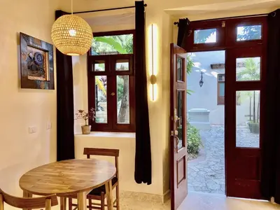 a dining room with a wooden table and a door at Paseo Colonial - Ermitage #5 in Santo Domingo