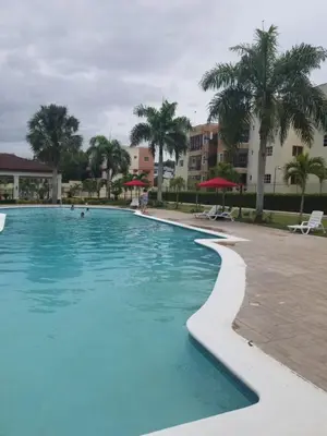 a large swimming pool with palm trees and buildings at SANTIAGO CITY in Santiago de los Caballeros
