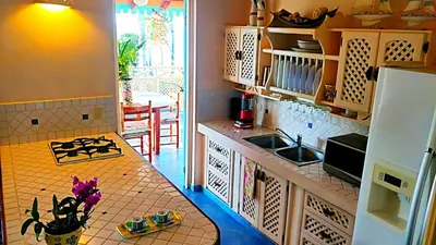 a kitchen with a counter and a sink and a table at La Dolce Vita 12 Beachfront Hotels, Las Terrenas, Samana in Las Terrenas