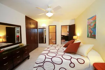 a bedroom with a large bed and a ceiling fan at Cabarete Palm Beach Condos in Cabarete