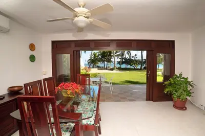a dining room with a ceiling fan and a glass table at Cabarete Palm Beach Condos in Cabarete