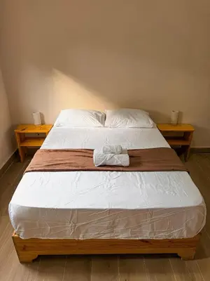a bed in a room with two nightstands and two tables at Gipsy Ranch Rooms in Cabarete
