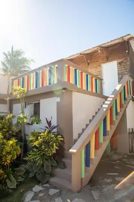 a house with rainbow stairs in front of it at Gipsy Ranch Rooms in Cabarete