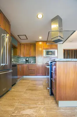 a kitchen with wooden cabinets and stainless steel appliances at Balcones Beach Penthouse in Las Terrenas
