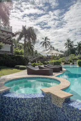 a swimming pool with chairs and a resort at Balcones Beach Penthouse in Las Terrenas