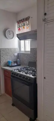 a kitchen with a black stove and a window at Residencial Palmas De Gurabo in Santiago de los Caballeros