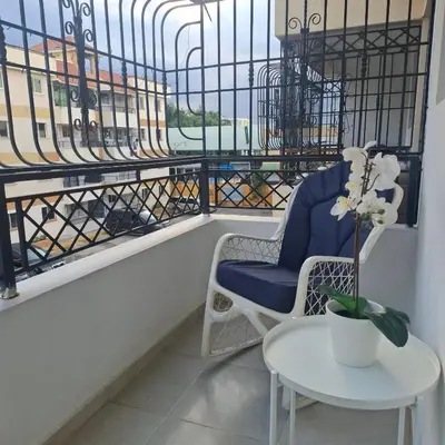 a balcony with a blue chair and a table at Residencial Palmas De Gurabo in Santiago de los Caballeros