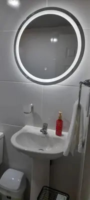 a bathroom with a white sink and a mirror at Residencial Palmas De Gurabo in Santiago de los Caballeros