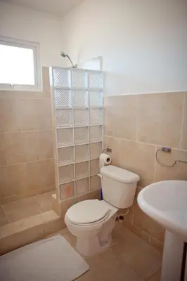a bathroom with a toilet and a sink at Kite Beach Inn in Cabarete