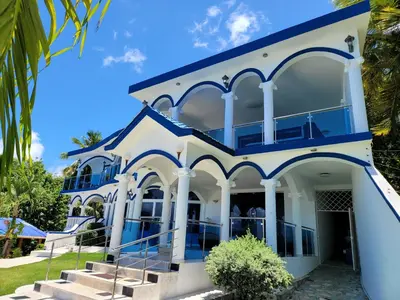 a large white building with blue accents at casaenjoysamana in Los Naranjos