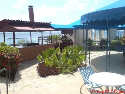a patio with a table and chairs and umbrellas at Sosua by the Sea in Sosúa
