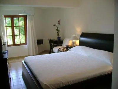 a bedroom with a bed and a chair and a window at Sosua by the Sea in Sosúa