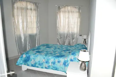 a bedroom with a bed with a blue comforter at Caribe Apartament S&D el castillo dominicus Apartamento #9 in Bayahibe