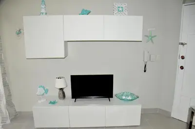 a living room with a tv on a white cabinet at Caribe Apartament S&D el castillo dominicus Apartamento #9 in Bayahibe