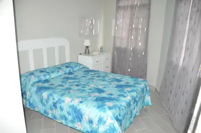 a bedroom with a bed with a blue comforter at Caribe Apartament S&D el castillo dominicus Apartamento #9 in Bayahibe