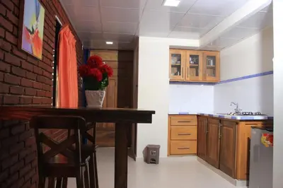 a kitchen with a table and a brick wall at Hotel Jaraba in Jarabacoa