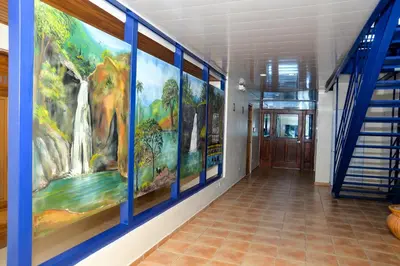 a hallway with a waterfall mural on the wall at Hotel Jaraba in Jarabacoa