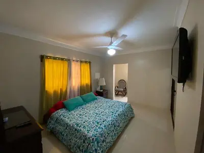 a bedroom with a bed and a ceiling fan at Oasis de paz in Jarabacoa