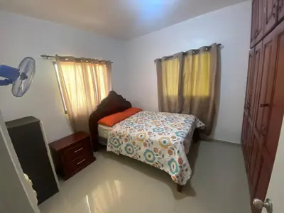 a small bedroom with a bed and a window at Oasis de paz in Jarabacoa