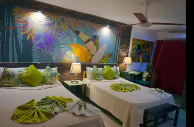 two beds in a room with a painting on the wall at Hotel Coco Plaza in Las Terrenas