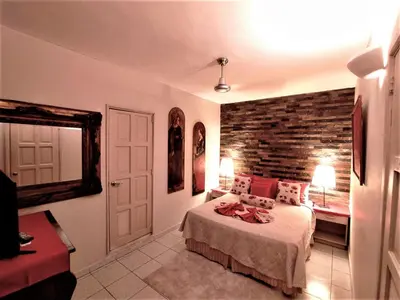 a bedroom with a bed and a brick wall at Hotel Coco Plaza in Las Terrenas