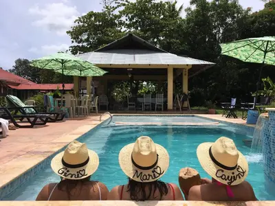 two people in straw hats sitting in a swimming pool at Campito Loving in Higuey