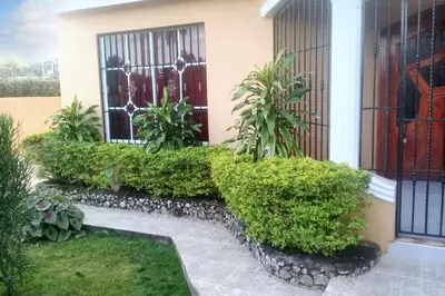 a garden with green bushes and a house at Elegant Villa in Nagua with Private Pool and Jacuzzi in Nagua