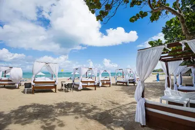 a row of chairs and umbrellas on a beach at Blue JackTar in San Felipe de Puerto Plata