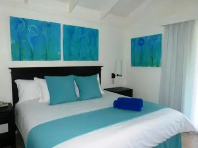 a bedroom with a large bed with blue pillows at Blue JackTar in San Felipe de Puerto Plata